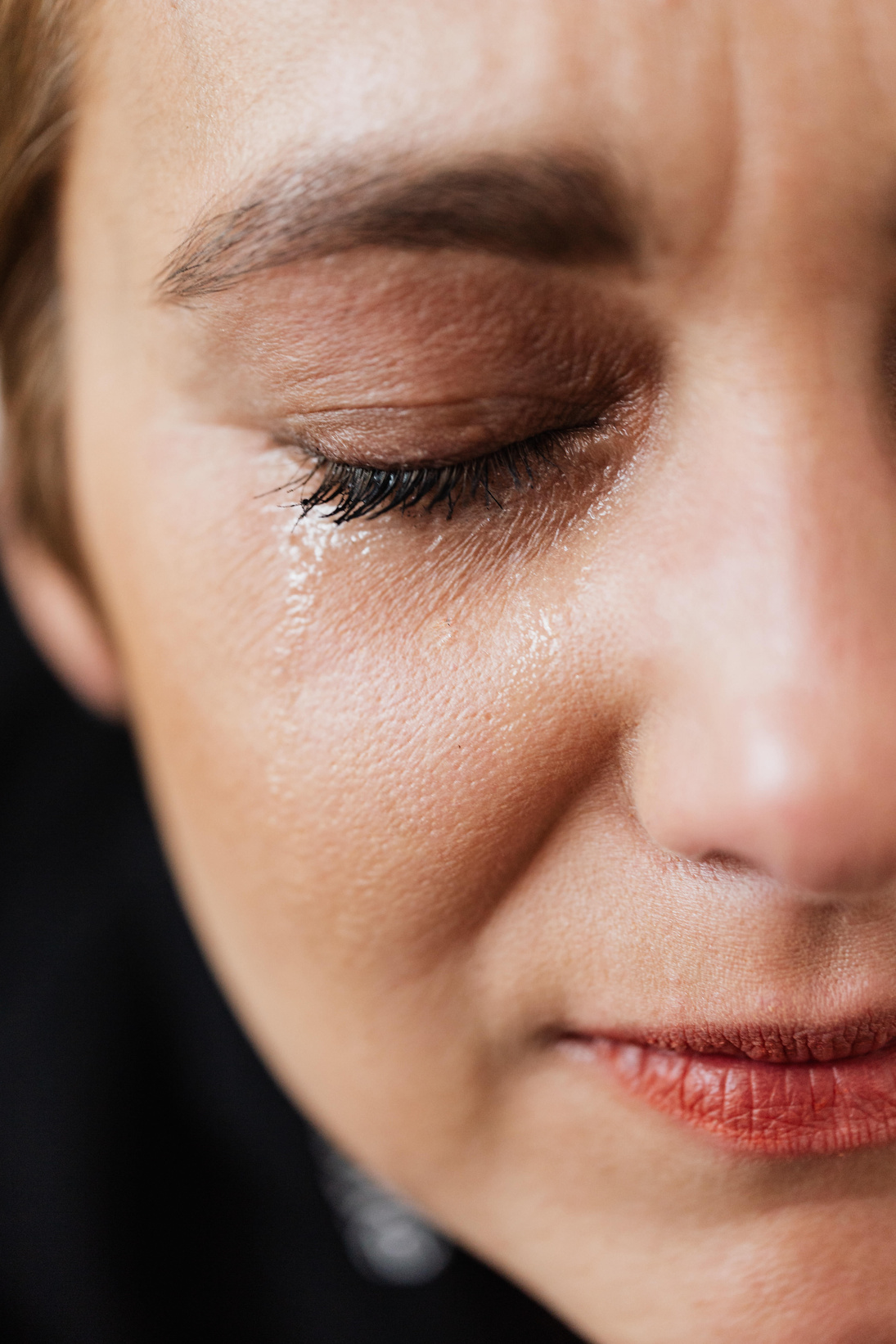 Lonely woman crying with closed eyes